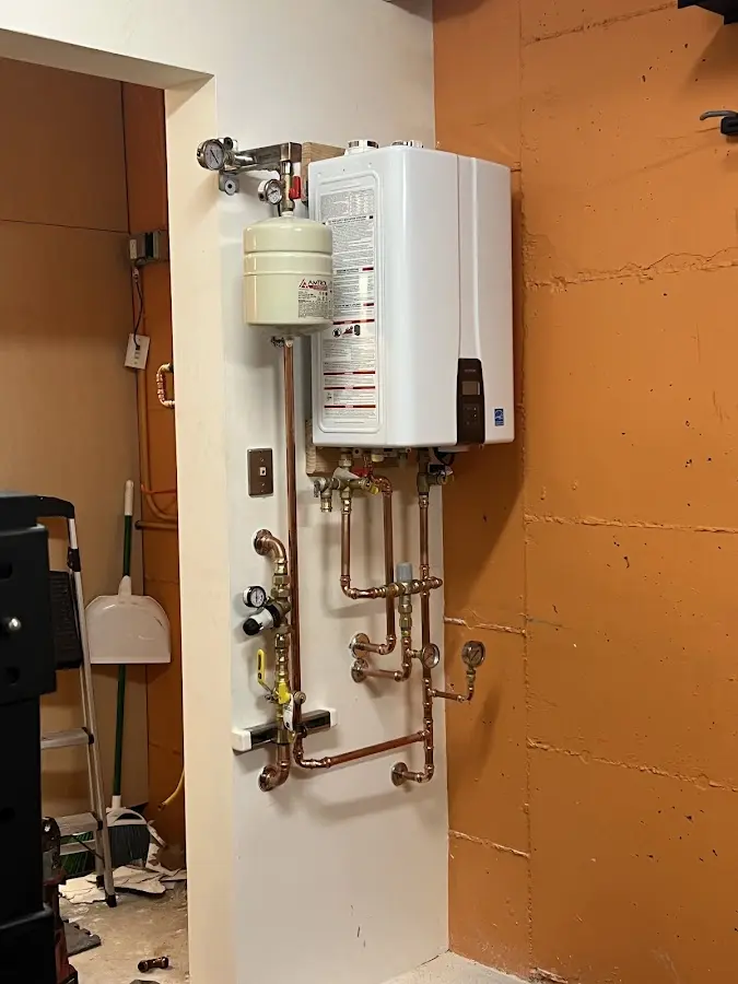 Plumbing technician inspecting water heater connections in Hatboro